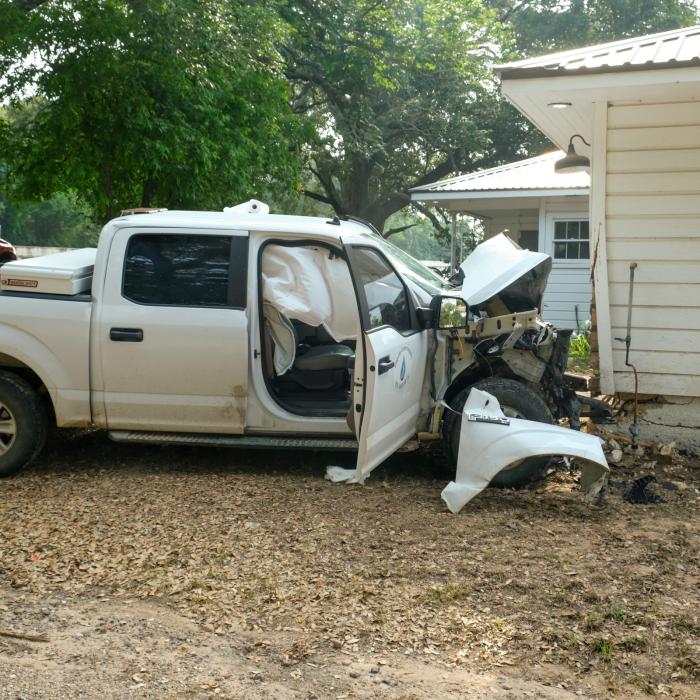 A white Ford pickup owned by Fayette Water Supply Corporation crashed into a Range Rover and then struck a house located a short distance off the highway.