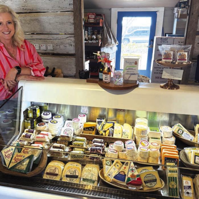 Melissa Steele stands by one of the displays of specialty cheeses at The Little Cheese Shop in Henkel Square in Round Top, which is housed inside an old 1830s building. Photo by Andy Behlen