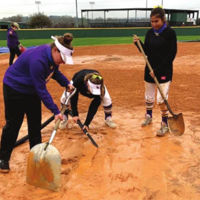La Grange players work on the wet softball field Thursday.