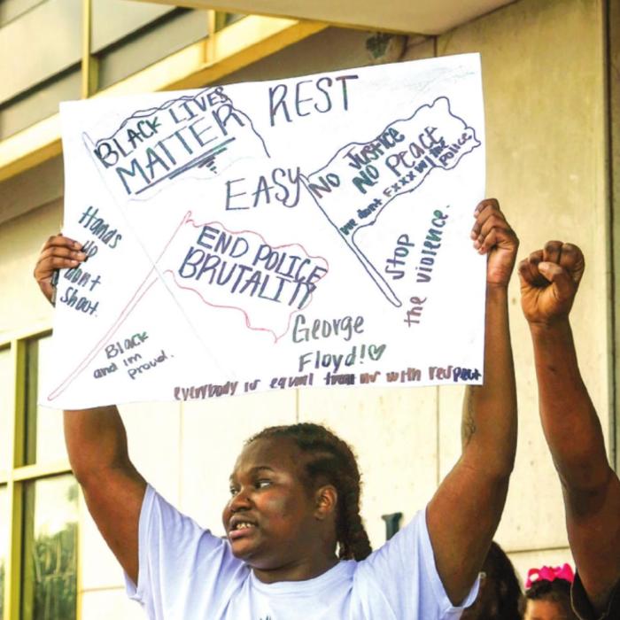 Diamond Houston holds up a sign as other protesters chant in front of Schulenburg City Hall at the Black Lives Matter demonstration in Schulenburg Wednesday evening, June 3. Photo by Andy Behlen