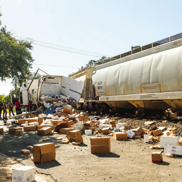 Witnesses reported a loud “boom” when the train hit the trailer that was loaded with groceries. Boxes of bread, buckets of pickles, tubs of hummus and jugs of milk went flying hundreds of feet down Lafayette St.
