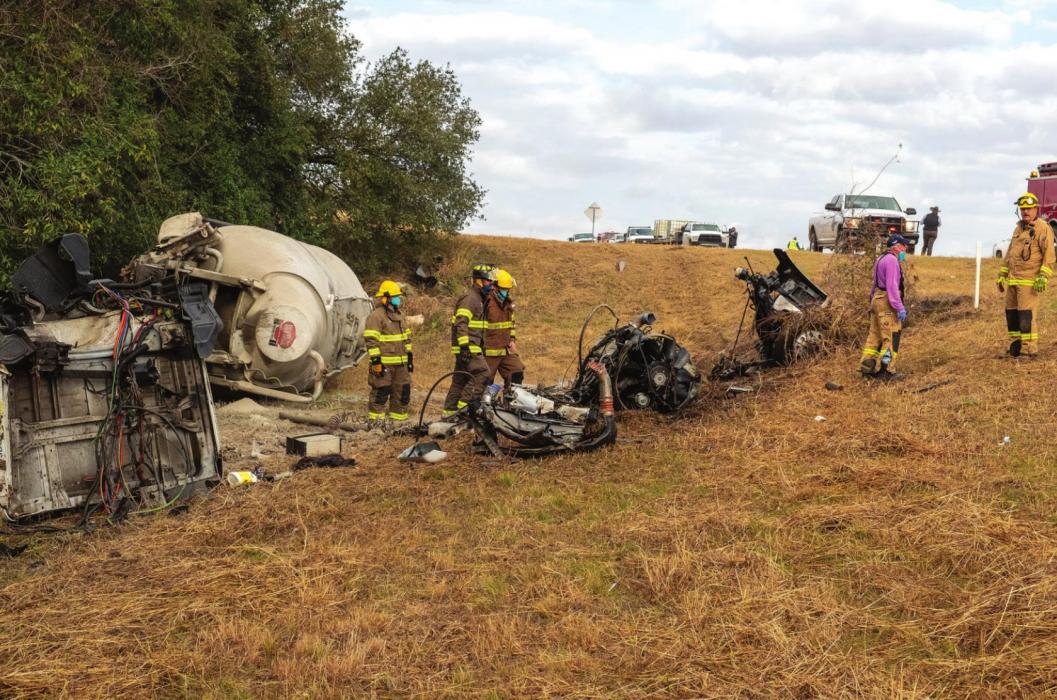 Ellinger firefighters examine the wreckage following an 18-wheeler rollover on SH 71 Monday morning. Photo by Andy Behlen
