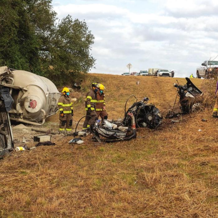 Ellinger firefighters examine the wreckage following an 18-wheeler rollover on SH 71 Monday morning. Photo by Andy Behlen