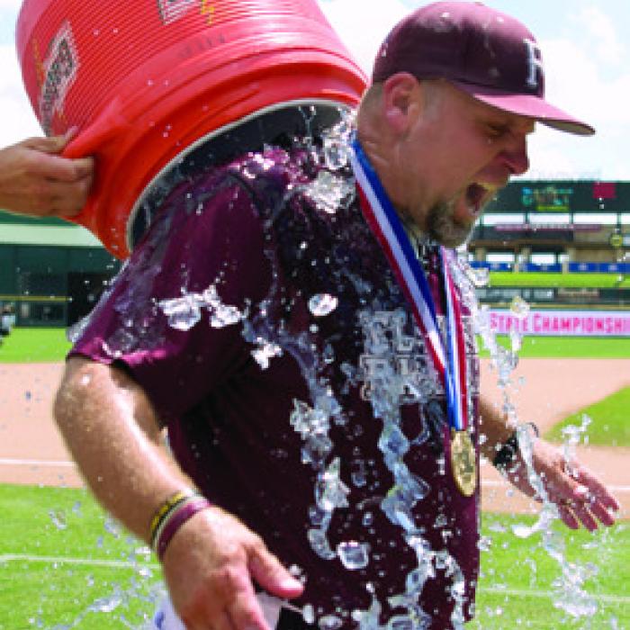 Flatonia head coach Shawn Bruns is doused with ice water by one of his players after the Bulldogs won the 2015 state title – one of three state baseball titles Bruns won at Flatonia.