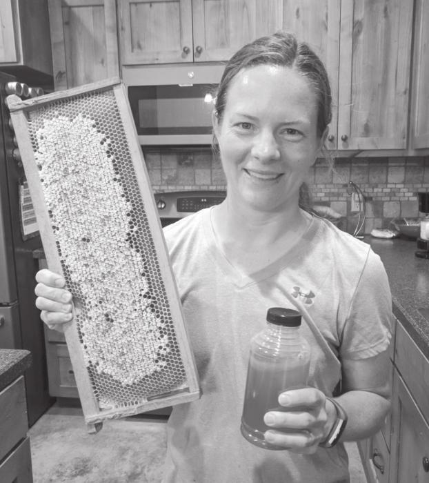 Kelli Biles with her honey comb and a jar of freshly collected honey.