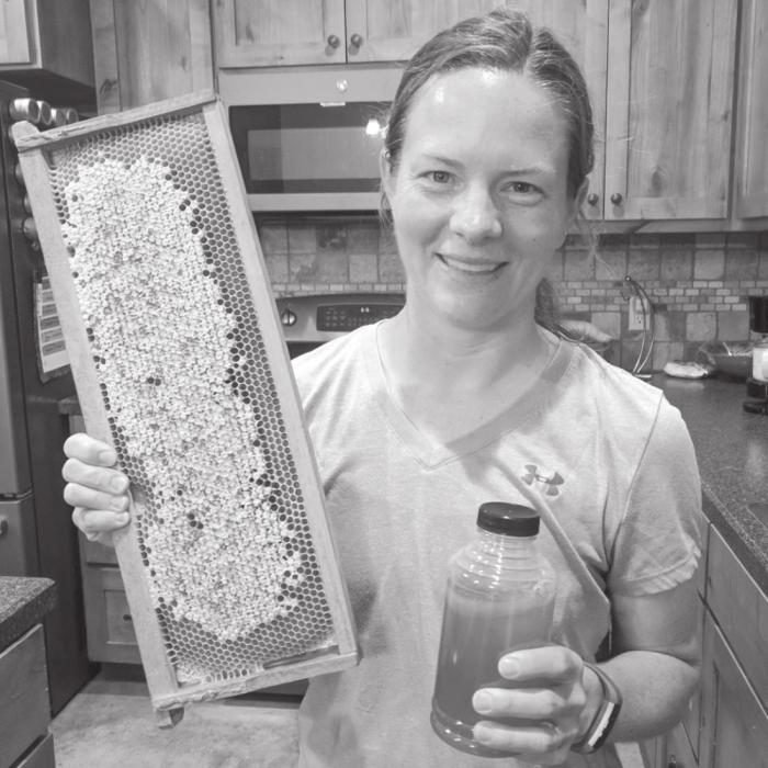 Kelli Biles with her honey comb and a jar of freshly collected honey.