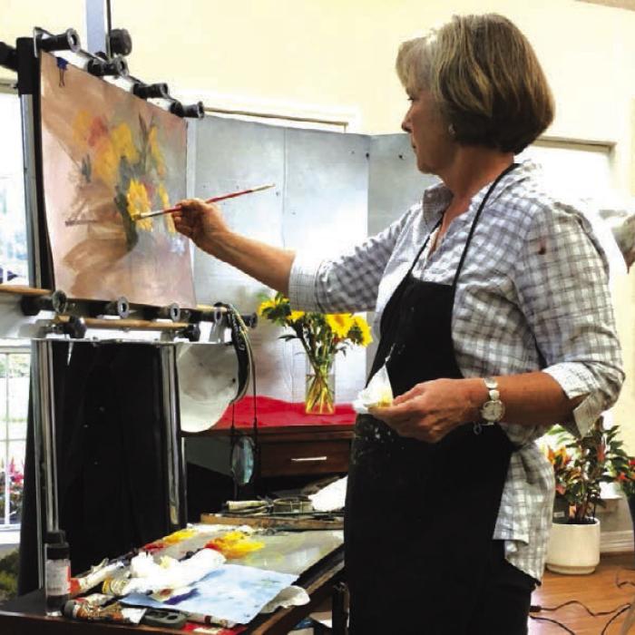 Fran Ellisor painting a still life in the studio.