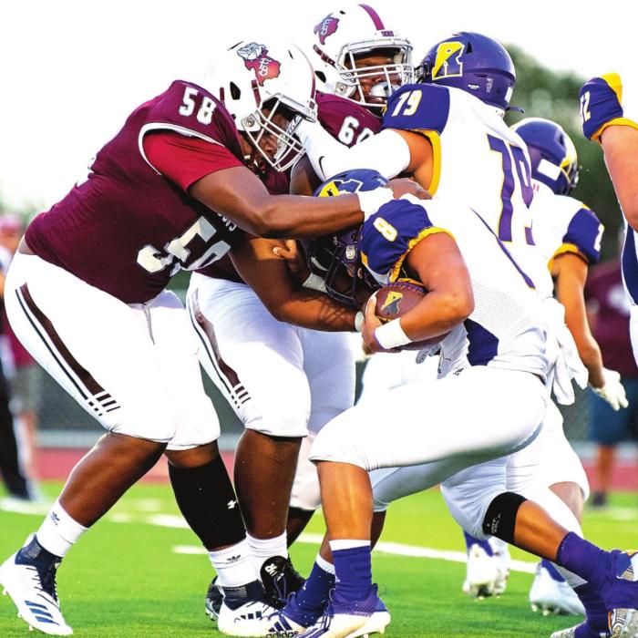 Devon Walles (58) and Kobe Burton (60) stop Runge from moving the ball down the field in Friday night’s 61-0 shutout. Photo by Stephanie Steinhauser