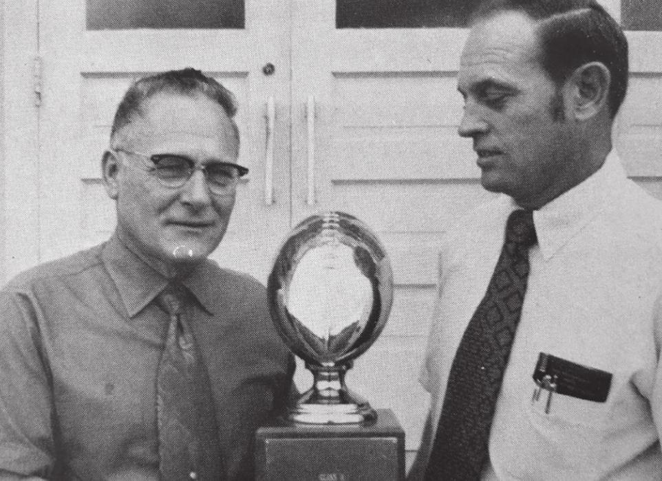 Tom Walker (right) presents the state championship trophy to Schulenburg ISD Superintendent A.C. Winkelman (left) following the big game in December 1972. Mr. Winkelman had been instrumental in bringing Tom to Schulenburg. Photo source: 1973 Schulenburg Roundup Yearbook.