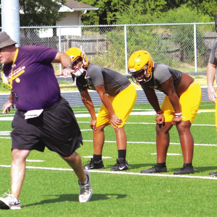 Head coach Matt Kates demonstrates a technique to La Grange players Monday.