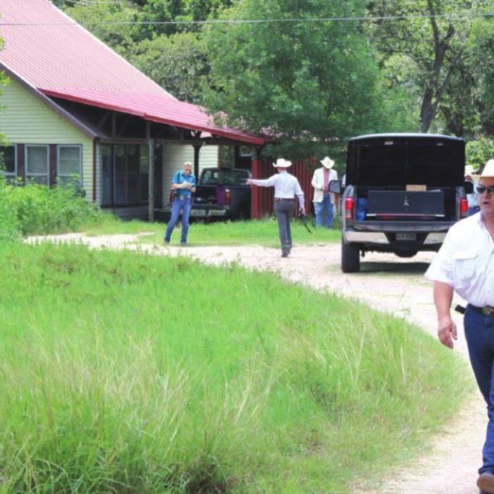 As Texas Rangers and county officers continue their investigation in the background, Fayette County Sheriff Keith Korenek walks up the driveway of the home on Creamer Creek Road outside La Grange where Jeremy Cornwell was shot and killed in 2017. Record File Photo by Jeff Wick