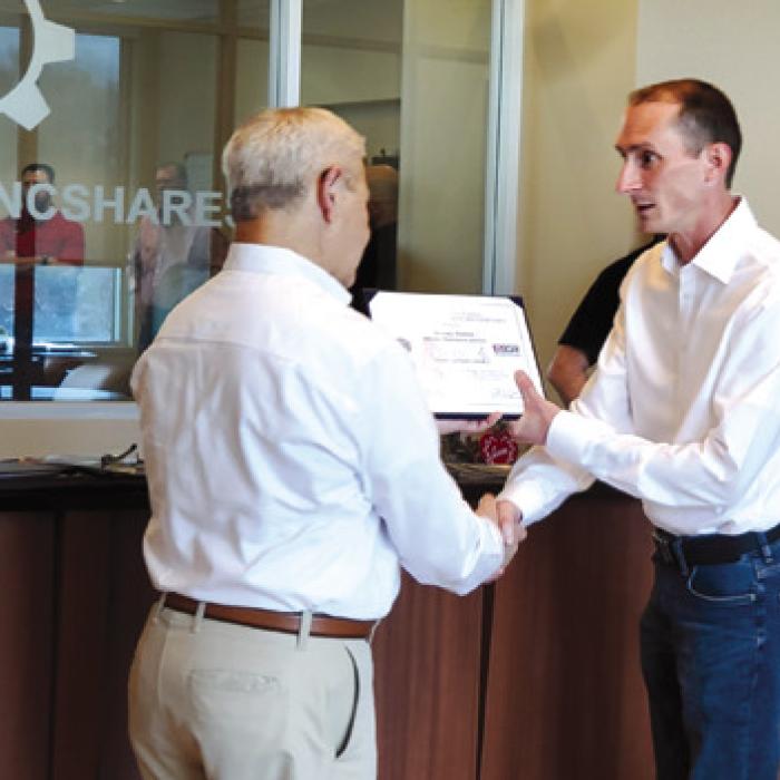 George Nami, Ombudsman Director of ESGR presenting award to VP of IT Infrastructure and Support Jeremy Pietsch.