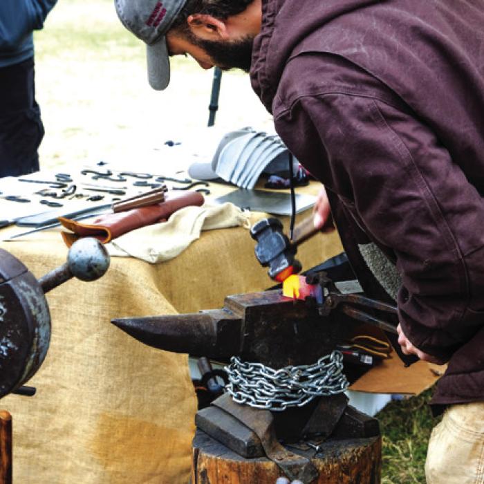 Berkeley Rhoads from the Texas A&amp;M Blacksmithing Club hammer forges a piece of metal during a demonstration.