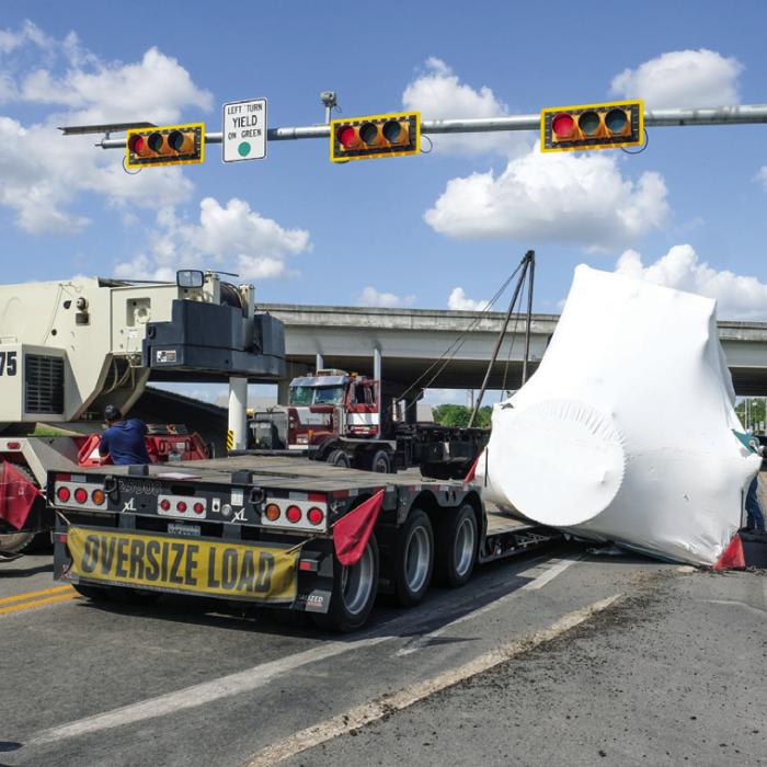 A big rig that turned from the Highway 71 Bypass north onto SH 159 lost its load near the 71 overpass in La Grange on Thursday. The load was a 75,000 lb. piece of air conditioning equipment, pictured above wrapped in white plastic. Photo by Andy Behlen