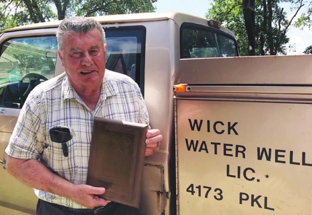 Leo J. Wick, who holds the plaque presented to him by the Texas Association of Fairs &amp; Events, drives one of the most recognizable vehicles in Fayette County. His Ford ¾-ton truck, that has over 360,000 miles, has probably been down every road in the area on water well service calls. It has been to the Fayette County Fairgrounds so often it could probably find its own way there. Photo by Elaine Thomas