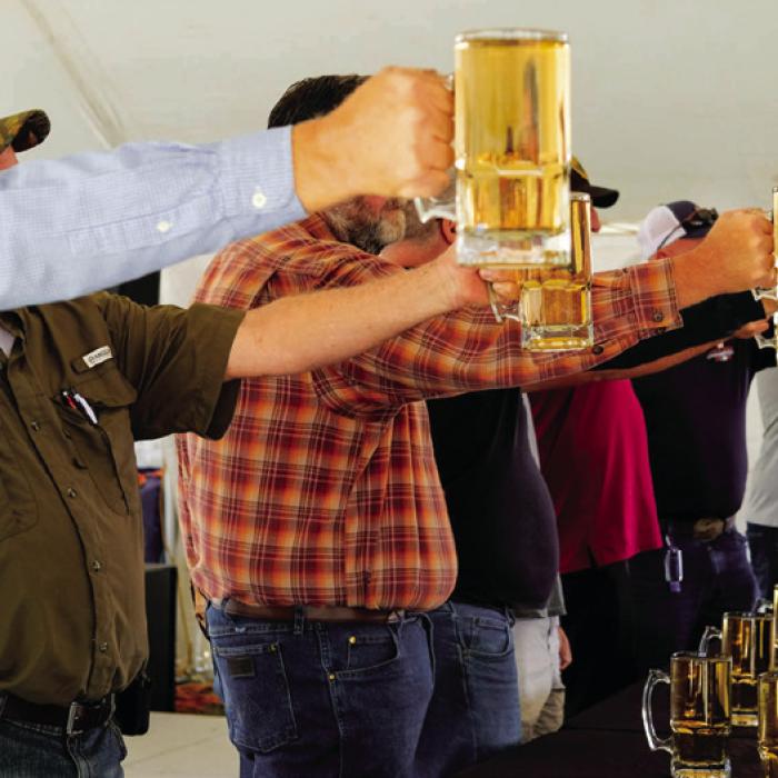 A group of men compete in the stein holding competition.