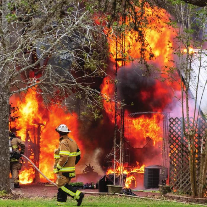 La Grange Fire Chief Frank Menefee directs firefighters fighting the house fire on FM 609 Monday afternoon.