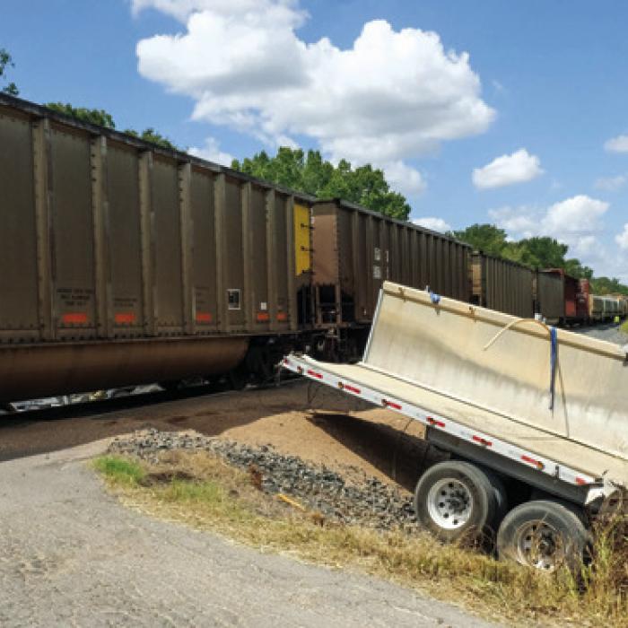 A Union Pacific train smashed through an 18-wheeler trailer hauling a load of gravel on Huelsebusch Rd. Tuesday around noon. The truck-tractor and part of the trailer ended up on the south side of the tracks (pictured left) while the back half of the trailer came to rest on the north side of the tracks (right). Photos by Andy Behlen