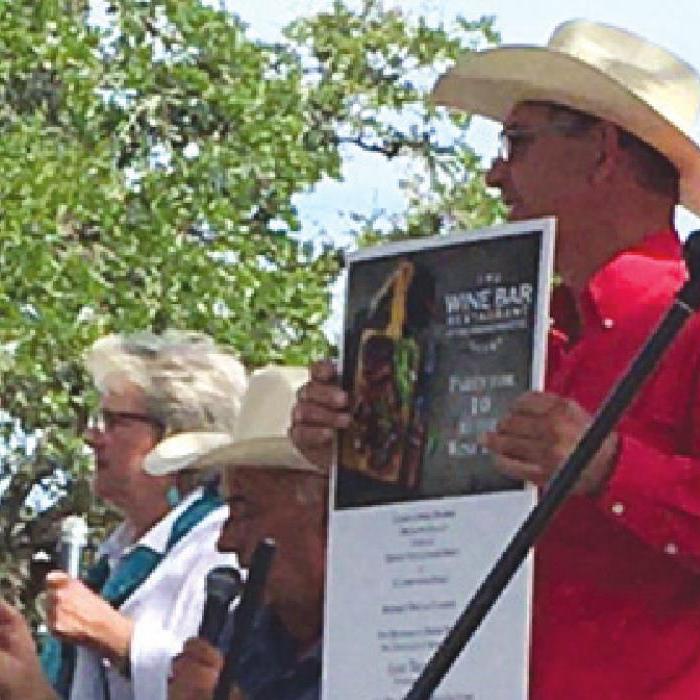 Artist Pat Johnson, Auctioneer Rick Sodek, and James Korenek holding Lickskillet Live Auction.