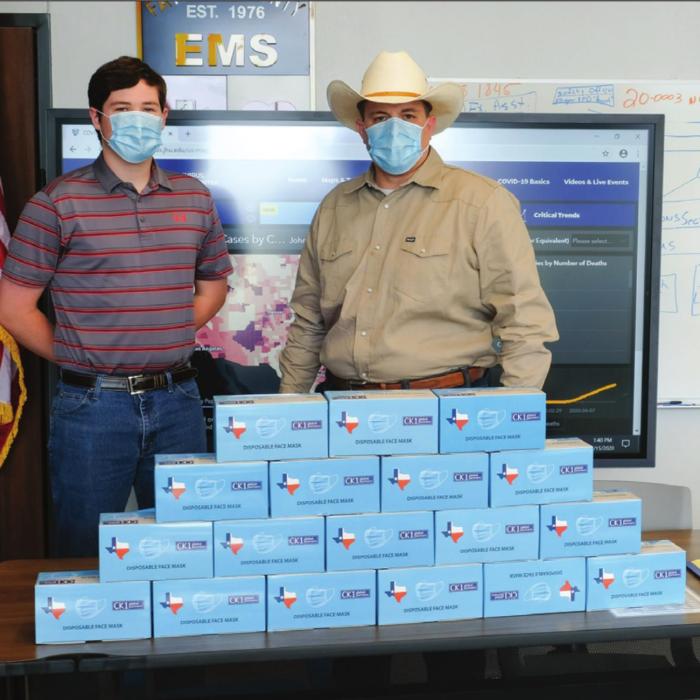 Fayette County Emergency Management Chief Craig Moreau (right) and intern Brendan Gilbreath (left) pose with some of the thousands of face masks that Schulenburg native Carman Kobza provided to the County’s emergency management department. Photo by Andy Behlen