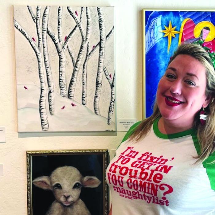 Jennifer Dittman in front of her painting of Aspens and Cardinals displayed at ARTS.
