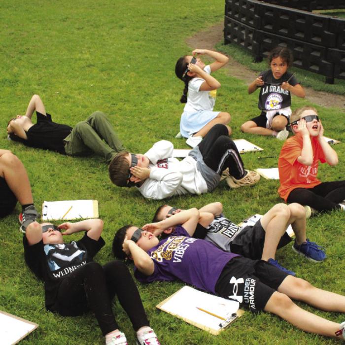 Students in Mrs. Hartmann’s first grade class at La Grange Elementary check out the eclipse Monday before a storm warning sent them hurrying inside. Photo by Jeff Wick