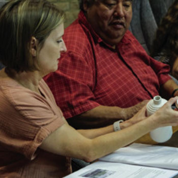 Council members Bonnie Busch and Arthur Bosque examine a sample ceramic bottle that the McGraths say would be manufactured on site for their La Grange gin to be sold in.