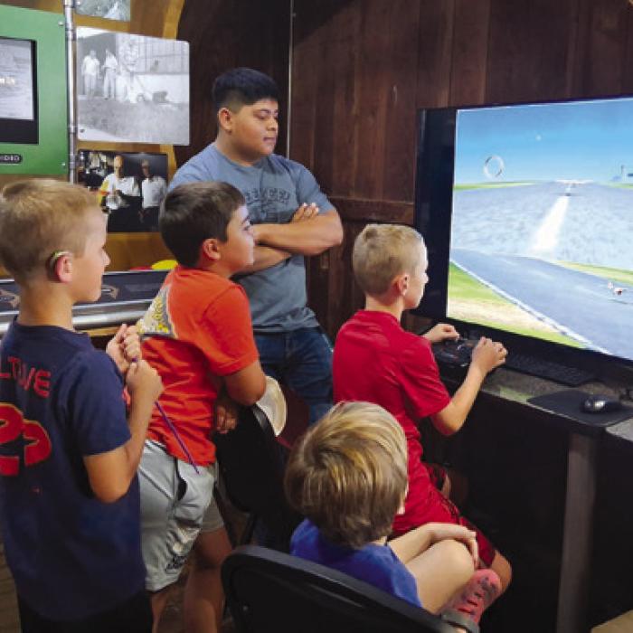 Volunteer Zuriel Robles guides the co-pilots on the Real Fight Simulator.