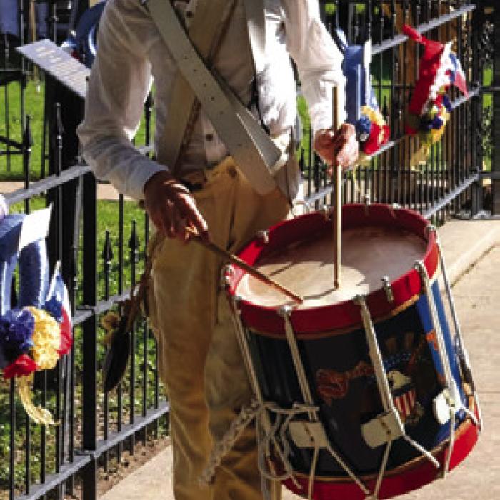 A drummer leads the Texas Army in a march around the tomb.