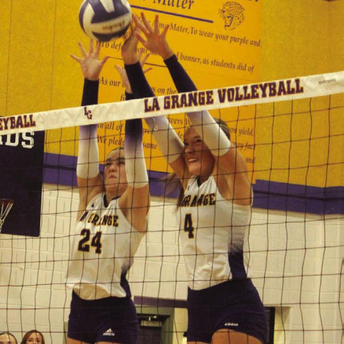 La Grange’s Kyndal Brawley, left, and Avery Griffin, right, jump to block a hit by a Sealy player in last Friday’s match. Photo by Jeff Wick