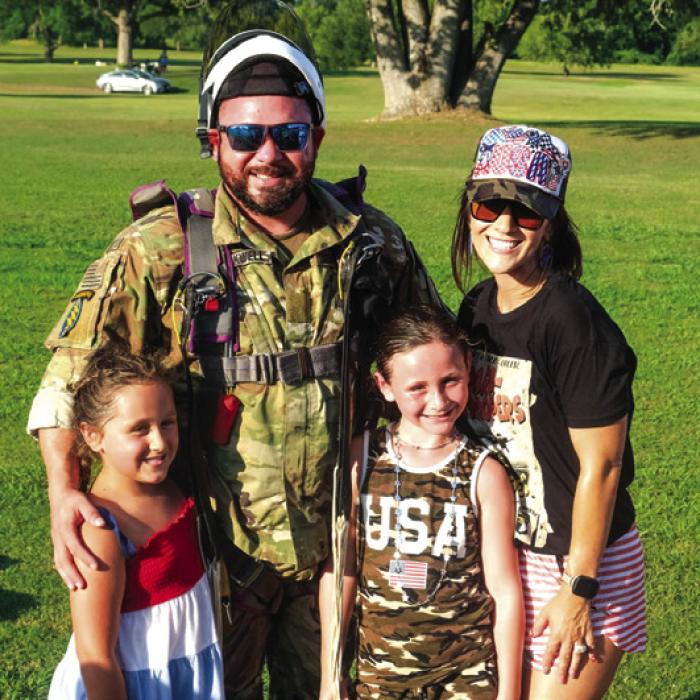 Local veteran and U.S. Army Paratrooper Dustin Blackwell jumped with the skydivers. He’s pictured here on the course after the landing with his wife Kelly and their children. Photos by Andy Behlen