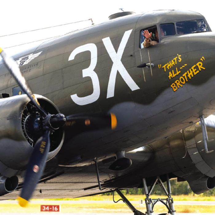 One of the pilots of the C-47 “That’s All Brother” waves to the camera as the plane taxied to the terminal at Fayette Regional Air Center