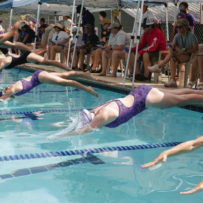 Swimmers dive into the water at the beginning of their first home meet Saturday at Camp Lone Star. Photo by Brittany Dawson