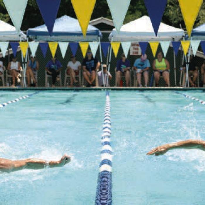 Swimmers with an army of timers and officials in the background Saturday. Photo by Brittany Dawson