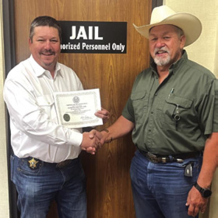 Brad Neville, left, new Jail Administrator, shakes hands with Sheriff Keith Korenek, as they show off their inspection certificate.