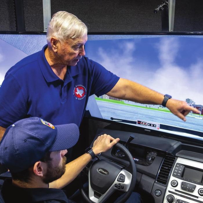 Don Courtney, a driving simulator consultant with the Texas Association of Counties, instructs Fayette County EMS medic Justin Laslie in safe driving techniques on Tuesday, Feb. 1. Photo by Andy Behlen