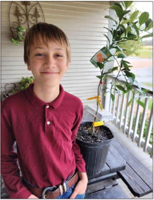 Abram Bernsen of Plum recently won a $200 Texas Farm Bureau Homeschool Garden Grant. He is pictured above with a Satsuma orange tree that he purchase last year with prize money from the Soil and Water Conservation District. The budding orchardman plans to use the Farm Bureau grant to purchase additional fruit trees.