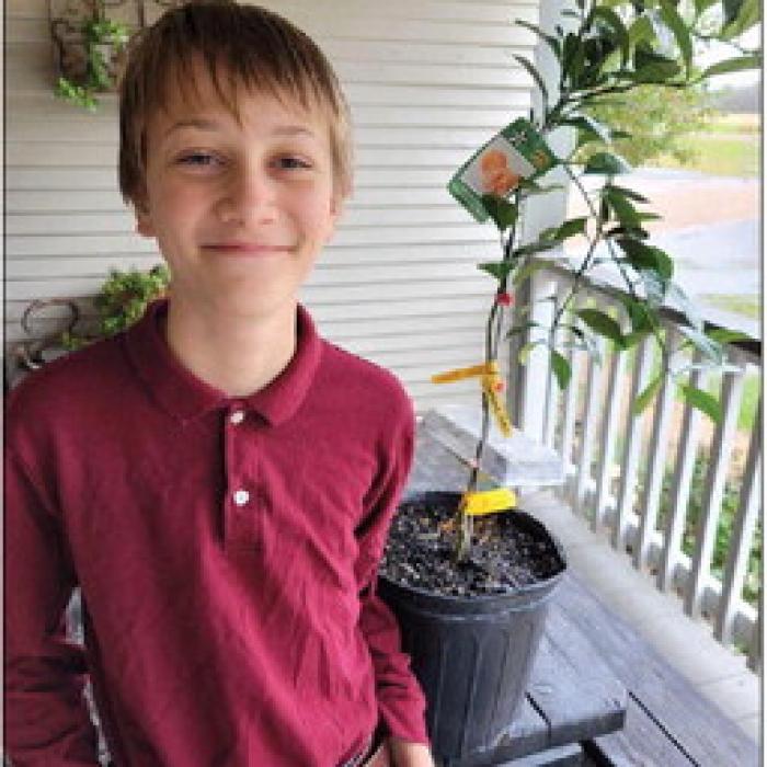 Abram Bernsen of Plum recently won a $200 Texas Farm Bureau Homeschool Garden Grant. He is pictured above with a Satsuma orange tree that he purchase last year with prize money from the Soil and Water Conservation District. The budding orchardman plans to use the Farm Bureau grant to purchase additional fruit trees.