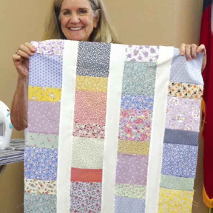 Gayle Jurica with a charity quilt.