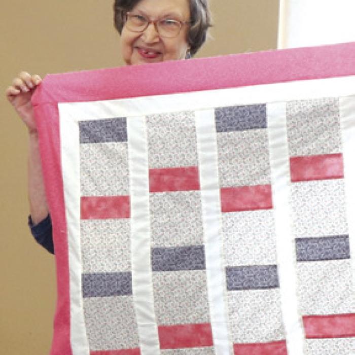 Barbara Schellberg with a finished charity quilt.