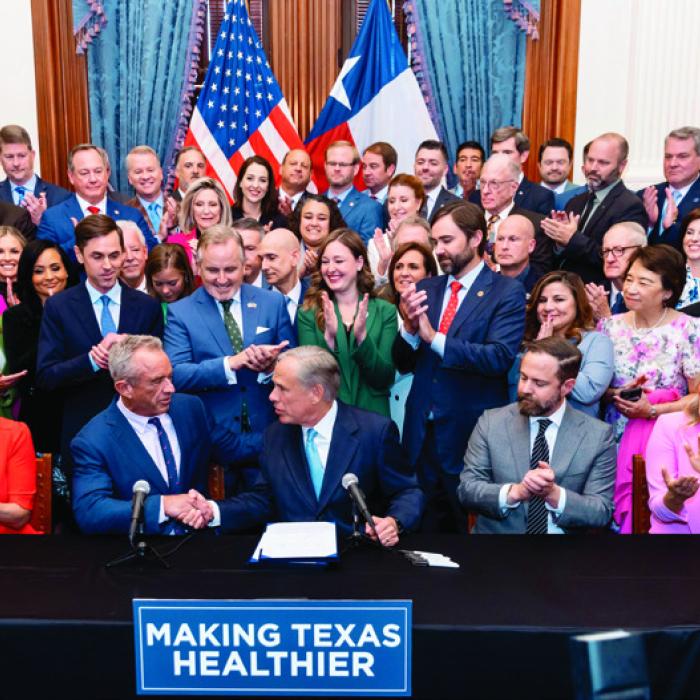 Governor Greg Abbott (front, center) shakes hands with U.S. Secretary of Health and Human Services Robert F. Kennedy, Jr., upon signing Senate Bill 25. The bill was authored by State Senator Lois Kolkhorst (pictured to the left of Kennedy). Kolkhorst represents Fayette County in the Texas Senate.