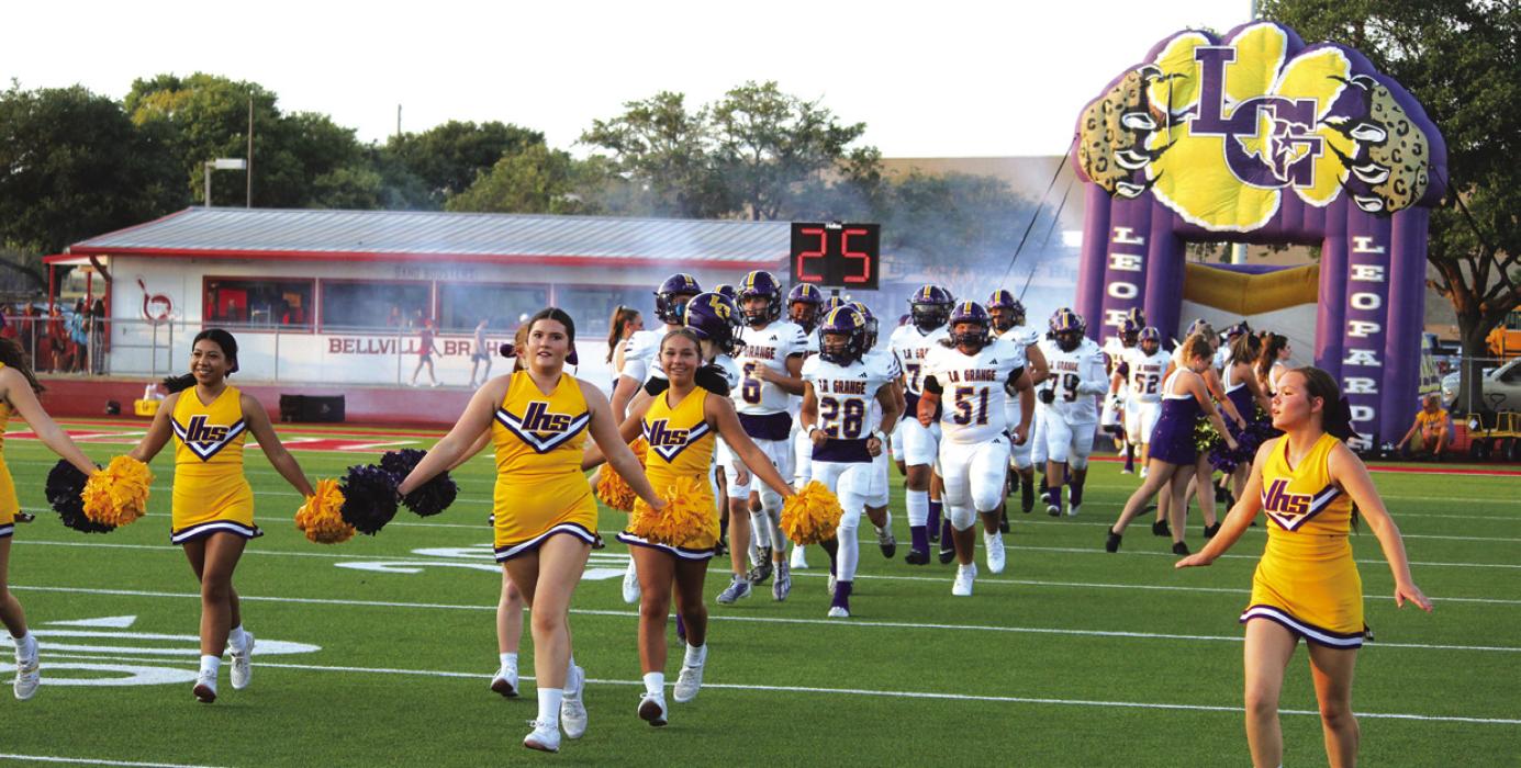 Led by the cheerleaders, the La Grange Leopards run onto the field at the start of Friday’s game. Photos by Jeff Wick