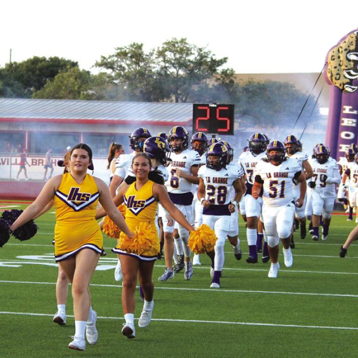 Led by the cheerleaders, the La Grange Leopards run onto the field at the start of Friday’s game. Photos by Jeff Wick