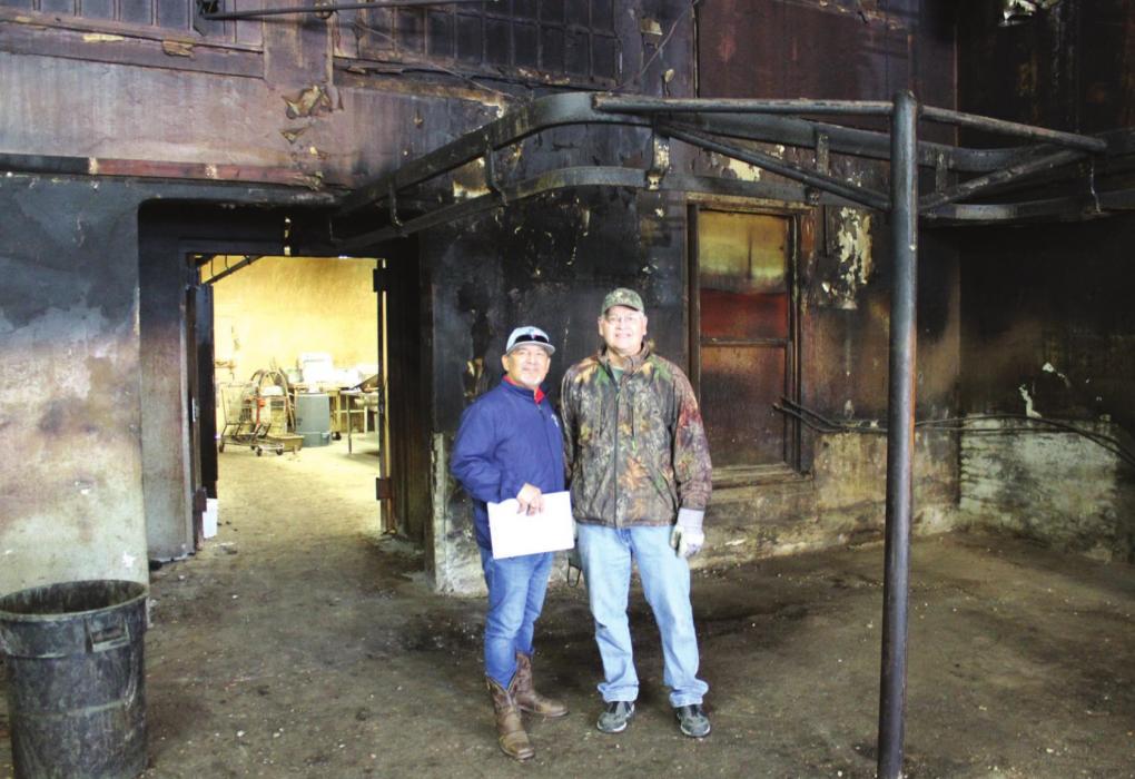 Decades of accumulation from barbeque smoke coat the walls at the old Prause Meat Market in La Grange. Tony Hinojosa, left, is part of the family who purchased the historic business last year to create the new Texas Prime Smokehouse and Meat Market there, but the Hinojosas are relying on the expertise of people like Gary Prause, right, to help them get started. Photo by Jeff Wick
