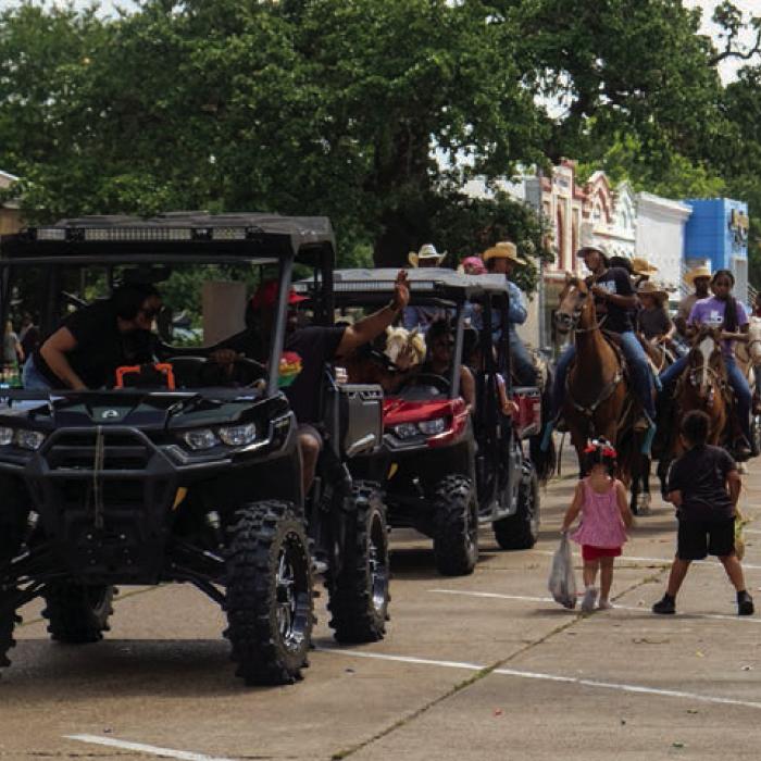 Cody Wilson, riding in a UTV, waves to the crowd as he leads the group of trail riders.