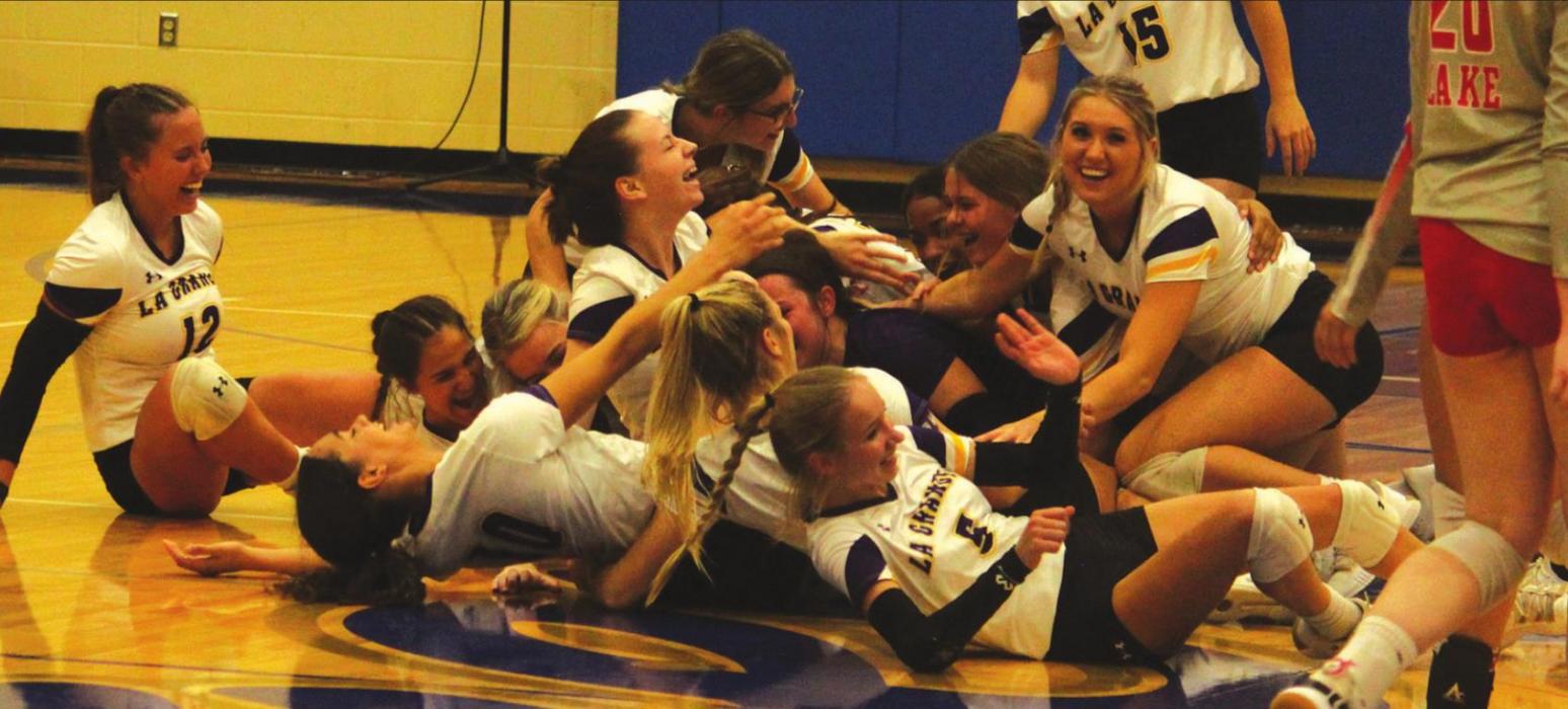 The La Grange girls dog-pile at midcourt in celebration after the Tuesday’s final point. Photo by Jeff Wick