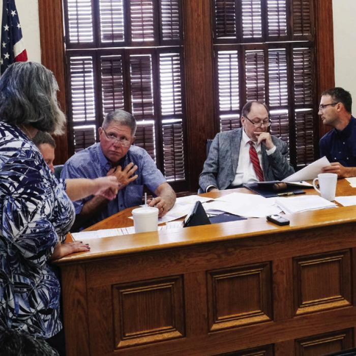 Commissioners and County Judge Dan Mueller review projected salary expenses with County Auditor Cindy Havelka (left) at last Thursday’s Commissioners Court meeting. Photo by Andy Behlen