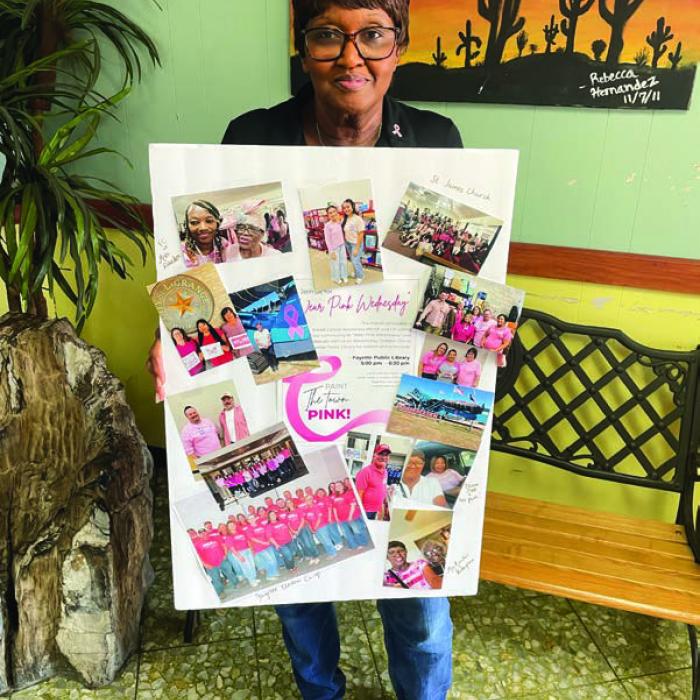 La Grange Mayor Jan Dockery organized a Breast Cancer Awareness event at the library on Oct. 15. She’s pictured here with a poster of employees at local workplaces who wore pink that day for breast cancer awareness.
