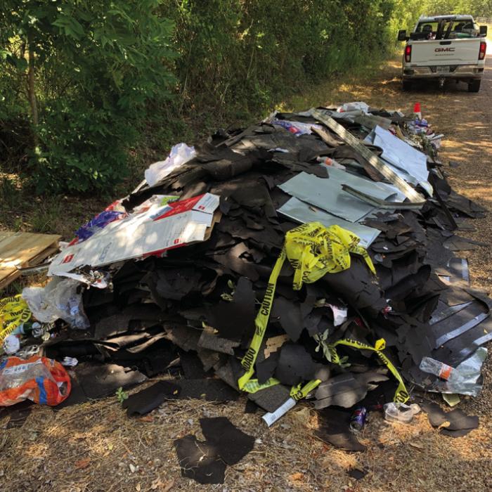 An out-of-town contractor allegedly dumped this pile of roof shingles and construction debris on Owl Creek Rd. last week.