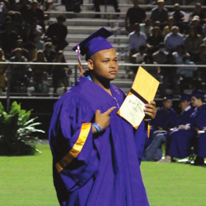 Tre Scott shows off his diploma as he walks back to his seat during Thursday’s ceremony.Photo by Jeff Wick